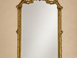 un miroir à cadre doré accroché à un mur beige dans une pièce