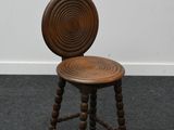 an image of a wooden stool with a wooden seat on a carpeted floor