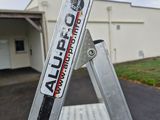 a ladder that has a sign on it in front of a building