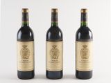 three bottles of wine sitting next to each other on a white surface