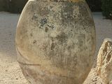 a large stone vase sitting in the middle of a gravel area