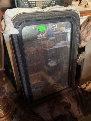 a mirror sitting on top of a table next to a lamp