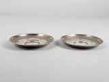 a pair of silver plated dishes on a white surface
