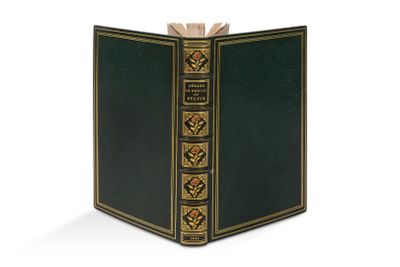 un vieux livre à la couverture verte posé sur une surface blanche