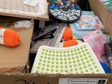 une boîte en carton remplie d'une multitude de fournitures de loisirs créatifs