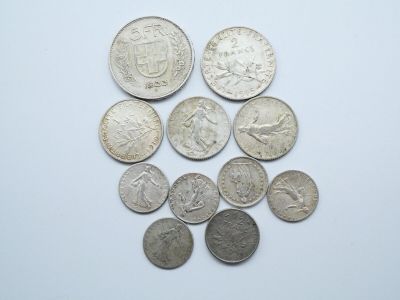 plusieurs pièces de monnaie sont disposées en cercle sur une surface blanche