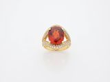 an orange garnet stone and diamond ring in yellow gold