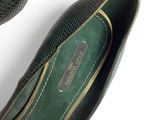 pair of black and green shoes on a white surface next to a basket