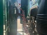 a green train that is parked next to another train