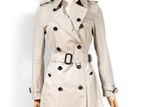 un mannequin blanc vêtu d'un trench-coat, posé sur un socle
