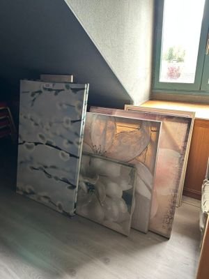 Plusieurs œuvres d'art sont posées par terre dans une pièce