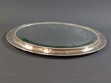 a silver plate with a mirror on top of it on a table