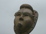une statue représentant un homme coiffé d'un chapeau, au sommet d'un poteau