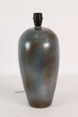 un vase bleu avec un couvercle noir posé sur une surface blanche