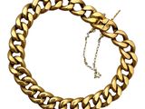 gros plan d'un bracelet en chaîne en or sur fond blanc