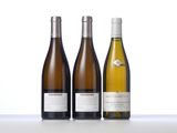 three bottles of wine are lined up on a table