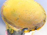 une personne tenant une tasse jaune avec un couvercle jaune