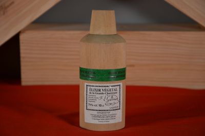 a bottle of liquid sitting on a red surface