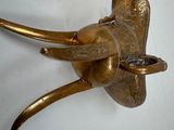 a brass elephant head mounted on a white wall