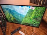 a tv that is sitting on the floor with a remote