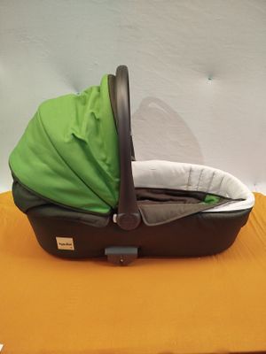 un bébé dans une poussette recouverte d'une housse verte