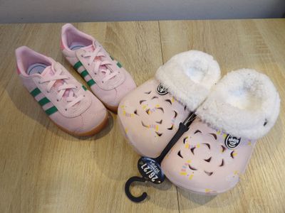 a pair of pink shoes and a pair of scissors on a table