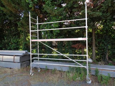 a scaffolding in the middle of a field next to some trees