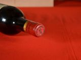 a bottle of wine sitting on a red table cloth