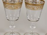 three wine glasses with gold rims on a white surface