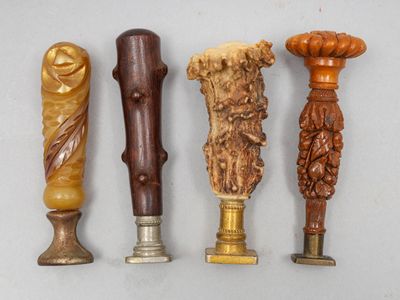 quatre types différents de bougeoirs en bois sculpté posés sur un fond blanc