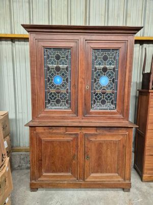 une armoire en bois surmontée de deux portes vitrées