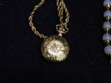 a necklace with a gold coin on it and a beaded necklace with a gold coin on it
