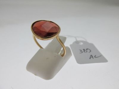 une image représentant une bague en or sertie d'une pierre rouge