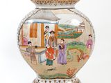 a vase with a painting on it sitting on a table