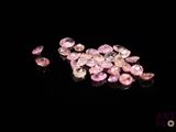 some pink diamonds on a black surface with a black background