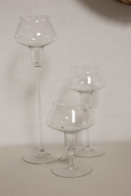 three wine glasses sitting on a table next to a clock