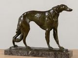 bronze statue of a dog on a marble base on a table