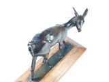 statue of a goat on a wooden base on a white background