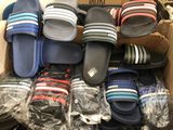 de nombreuses paires de chaussons dans une boîte posée par terre