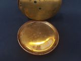 a gold pocket watch sitting on top of a black table