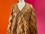 brown leather jacket on a mannequin stand against a red wall