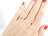 a woman ' s hand with a diamond ring on it