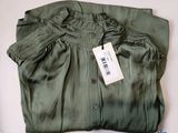 une chemise verte avec une étiquette, posée sur une table