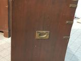 a brown suitcase sitting on the floor next to a dresser