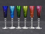 six different colored wine glasses lined up in a row