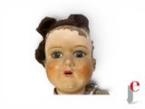a doll with a brown hair and a brown bow on it