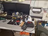 a desk with a computer monitor and other electronics on it