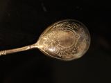 a silver spoon with a design on it sitting on a table
