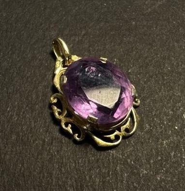 an image of a purple stone pendant sitting on top of a table