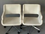 une paire de chaises blanches à roulettes sur fond gris